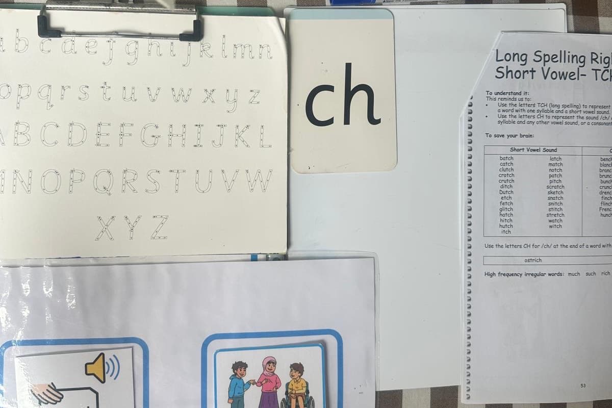 A handwriting whiteboard showing the split digraph 'i-e', next to phonics picture cards and dry-wipe pens.
